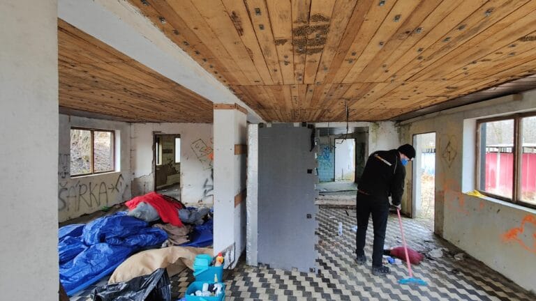 Muž uklízí zanedbaný byt, vyklízení prostor po bezdomovcích.