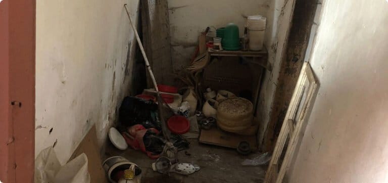 Zaneřáděný sklep před vyklizením.