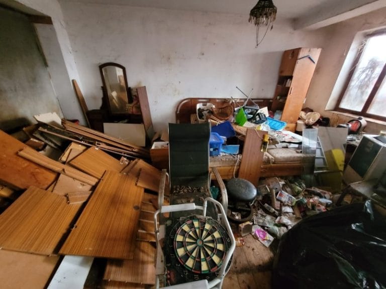 Zaneřáděný nepořádek v místnosti před vyklizením a úklidem.