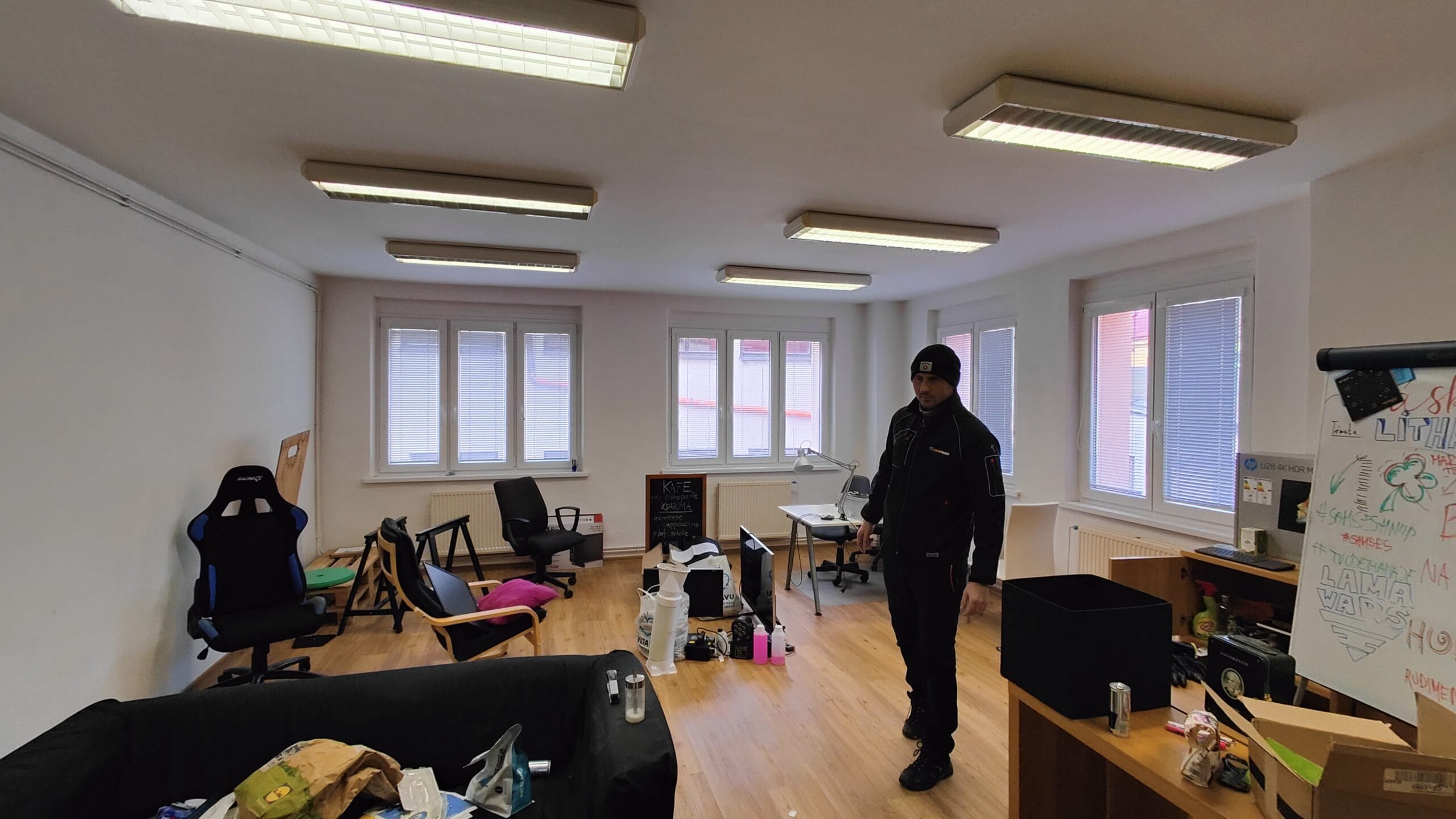 Muž v černé kombinéze při vyklízení kanceláře.